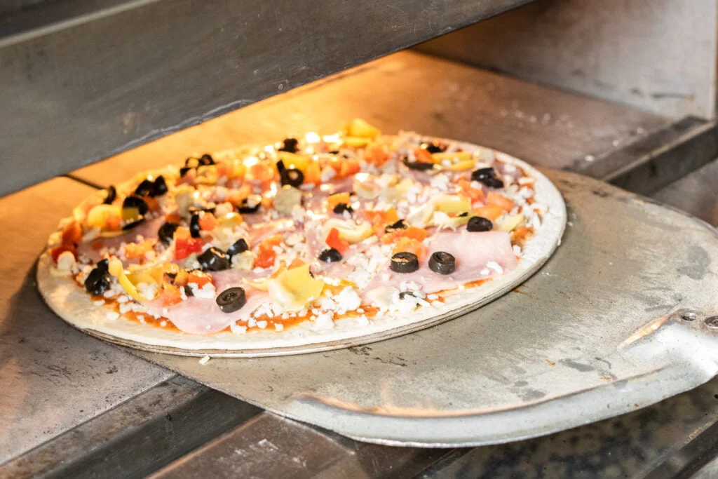 Pizza en preparación para servir a la mesa