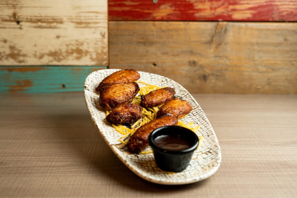 Alitas de pollo caramelizadas con salsa barbacoa y patatas paja