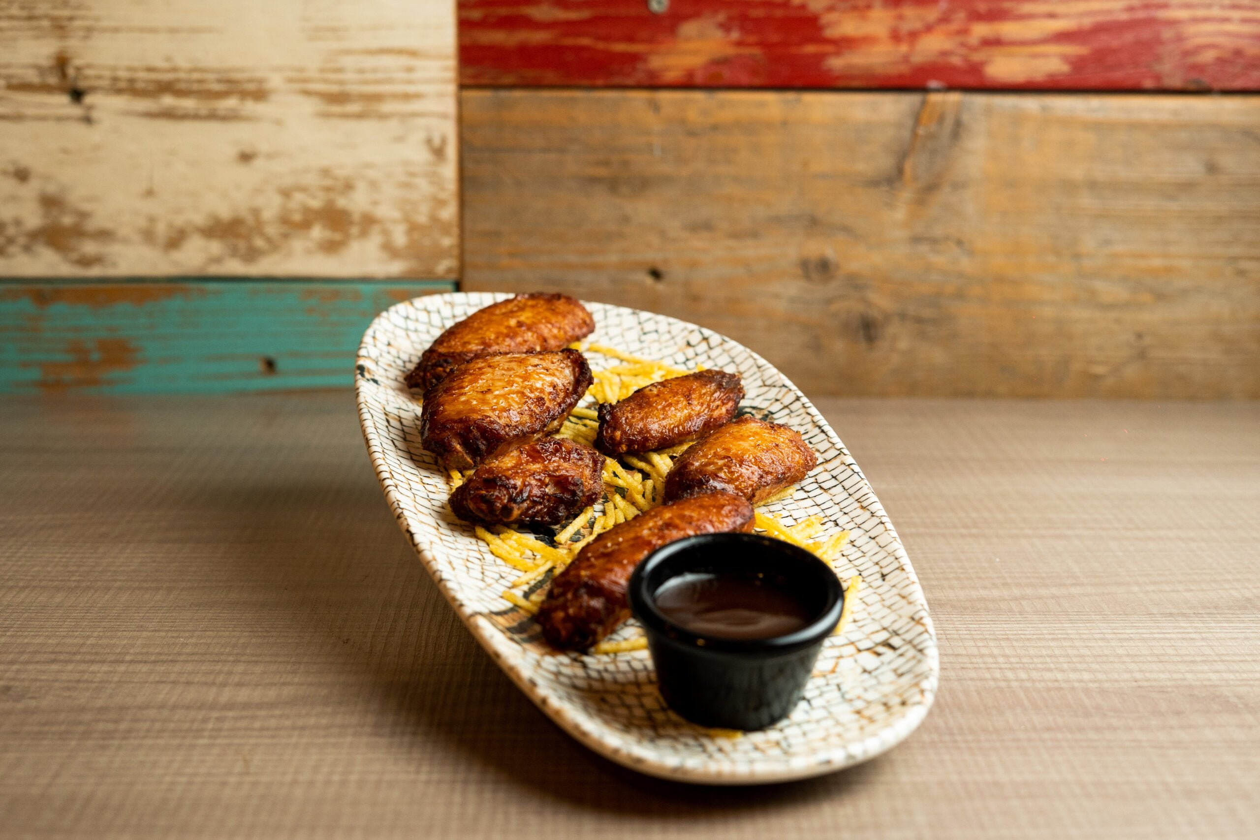 Alitas de pollo caramelizadas con salsa barbacoa y patatas paja
